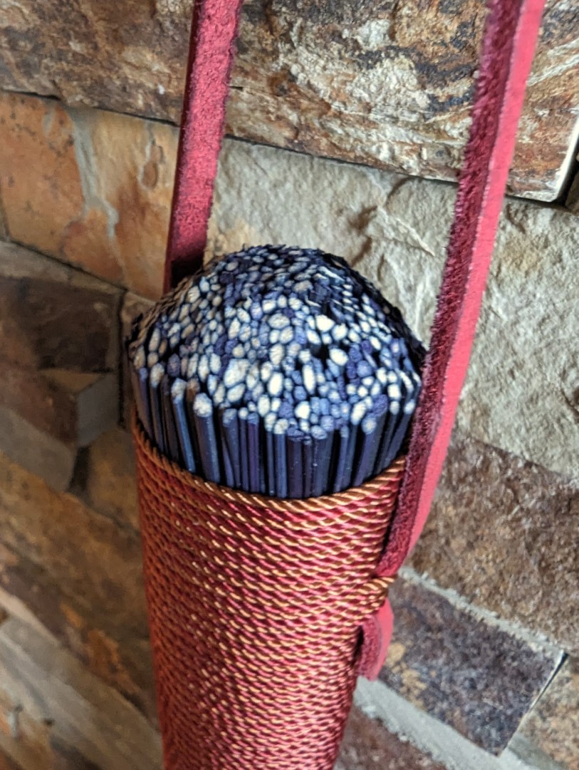 Hand broom handle end is carved into a dome shape.