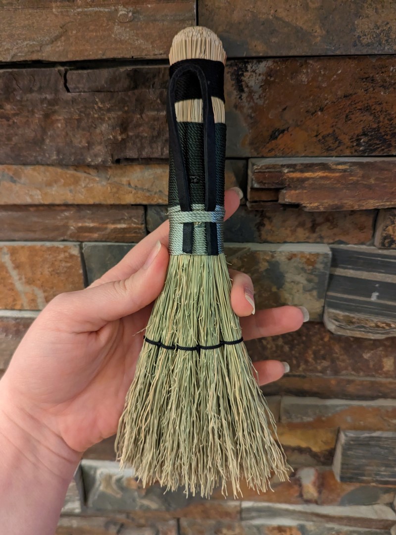 Back of broom with black leather hangtag