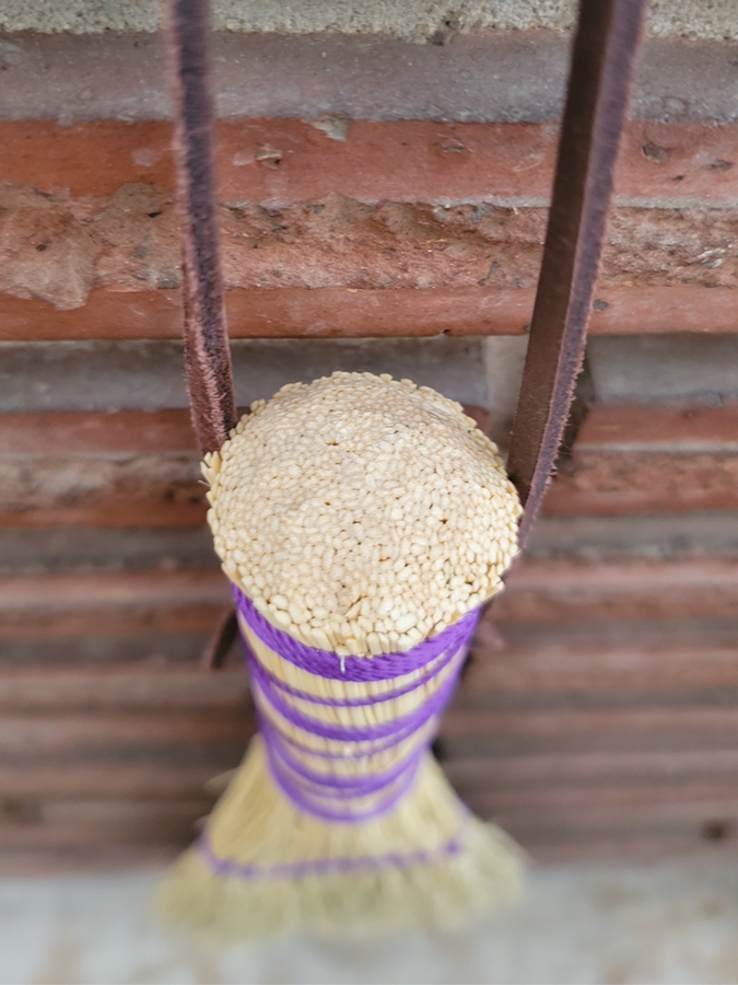 Natural broomcorn is carved to a rounded dome on top of handle
