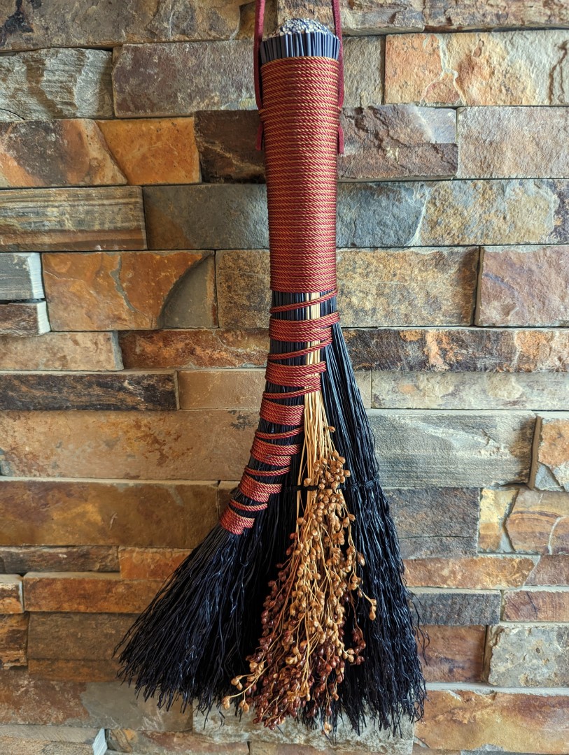 Overview shot of hand broom hanging on brick hearth
