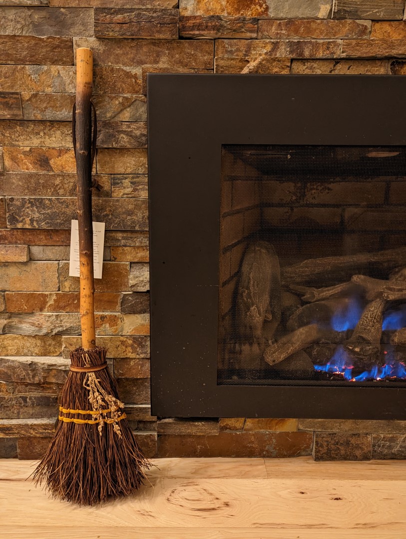 Hearth broom by the fireplace